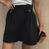 Military-inspired black shorts with button details, white top, and gold accessories for trendy look