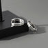 Two hexagonal silver hoop earrings with Roman numeral engravings on black display