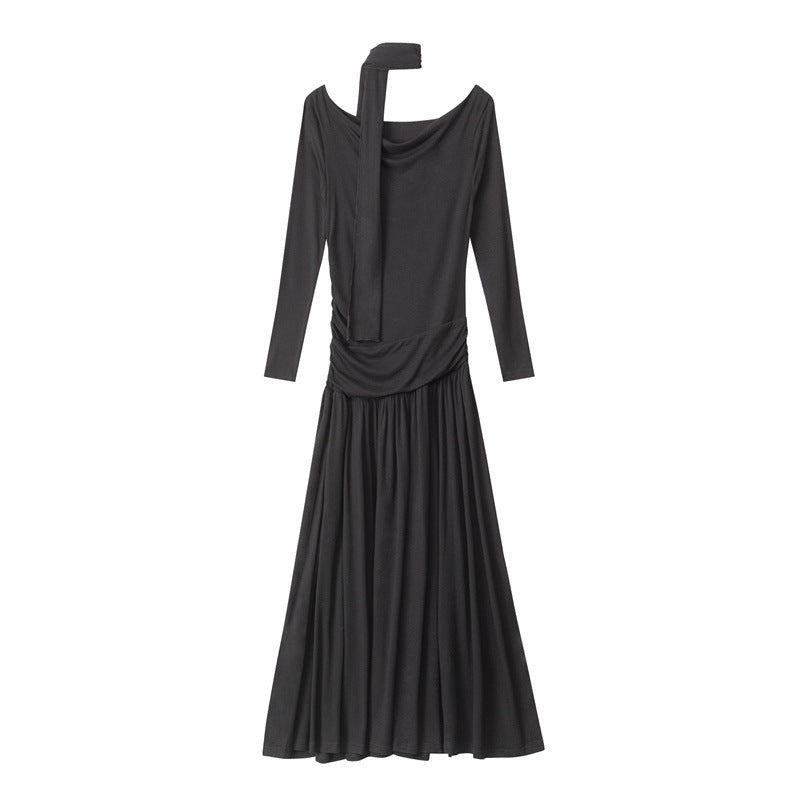 Full product shot of black jersey maxi dress with off-shoulder neckline, attached scarf, ruched waist, and floor-length gathered skirt