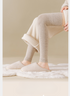 Cream knit leg warmers and beige slippers on plush white rug