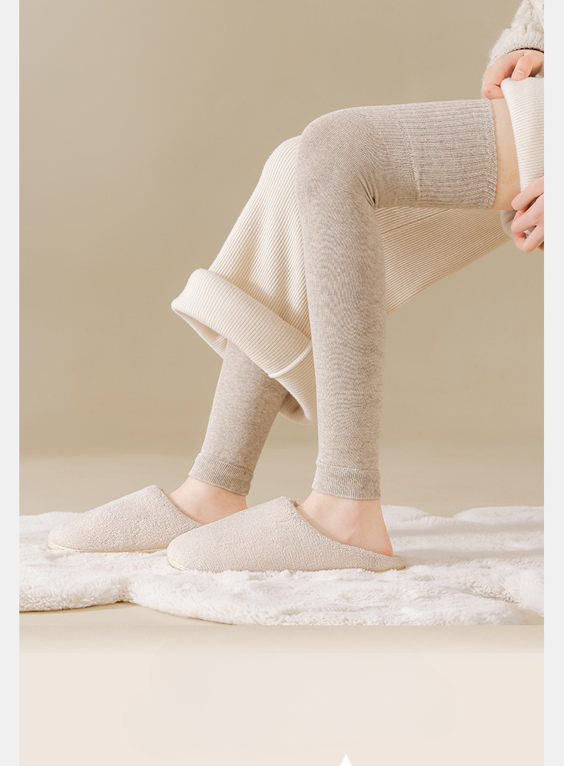 Cream knit leg warmers and beige slippers on plush white rug