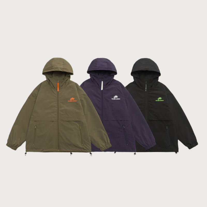 Three hooded windbreaker jackets in olive, navy and black with bicycle logo embroidery displayed against light gray background