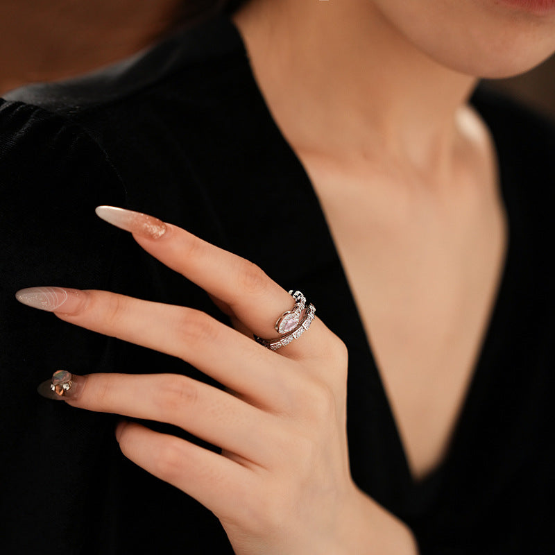Elegant snake-shaped diamond ring on hand with nude nail polish