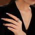 Elegant snake-shaped diamond ring on hand with nude nail polish