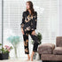 Black silk women's pajama set with golden dragon pattern, highlighting sleek silhouette and classic loungewear design