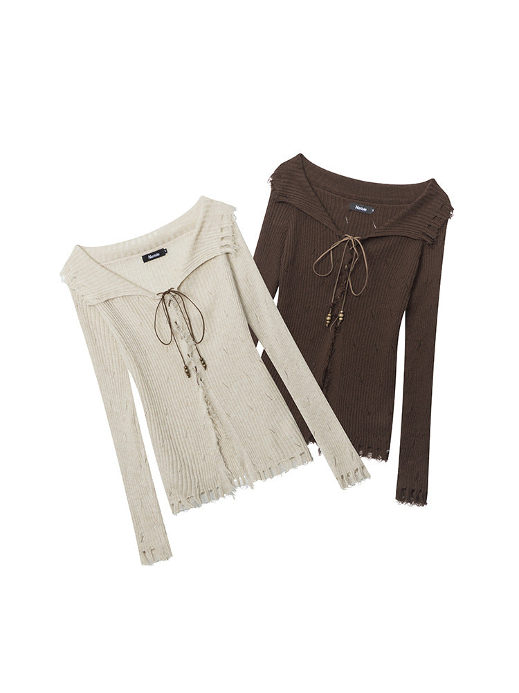Two ribbed knit sweaters with lace-up front detailing - one in cream and one in brown. Both feature distressed hem and cuffs, and decorative beaded ties