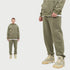 Model wearing olive green hoodie and sweatpants with white undershirt and beige Jordan sneakers, shown in split-view format