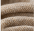 Detailed texture view of cream knit leg warmer fabric