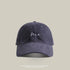 Navy blue baseball cap with 'Me' embroidered in white cursive, adjustable strap, and a classic streetwear fit