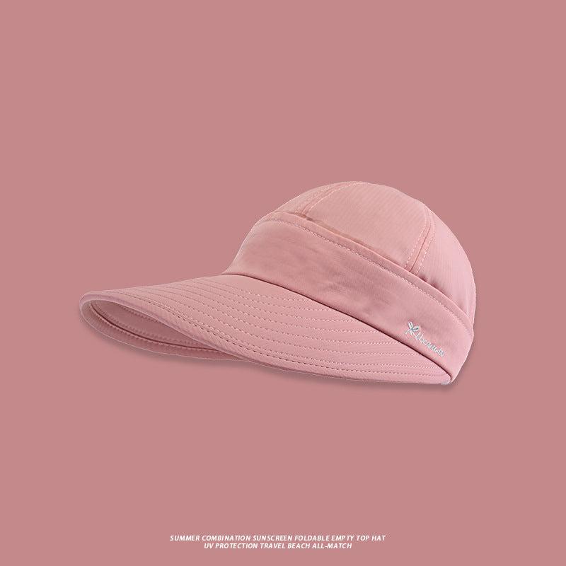 A pale pink wide-brim sun visor hat with UV protection features and small brand logo detail against matching pink background