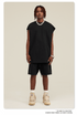Male model wearing black oversized tee and matching shorts with beige Jordan sneakers and silver jewelry