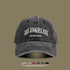Charcoal gray washed cotton baseball cap with white embroidered Los Angeles text against neutral background
