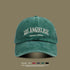 Forest green washed cotton baseball cap with white 'LOS ANGELES VINTAGE MADE' embroidery displayed on olive background