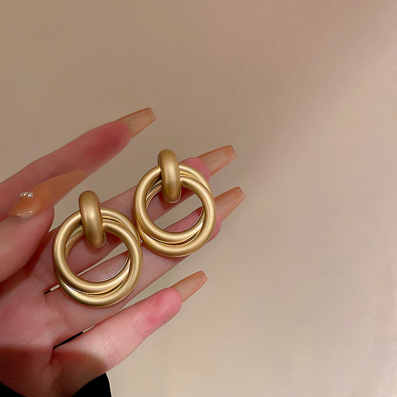Double-ring gold statement earrings shown with matte finish