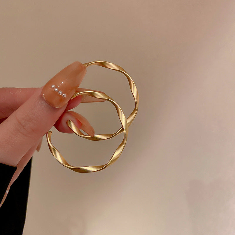 Minimal twisted circle earrings in gold finish