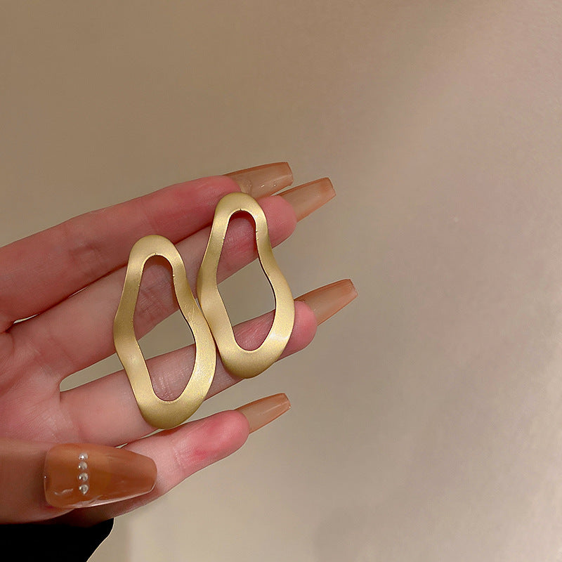 Asymmetric gold disc earrings with organic shape