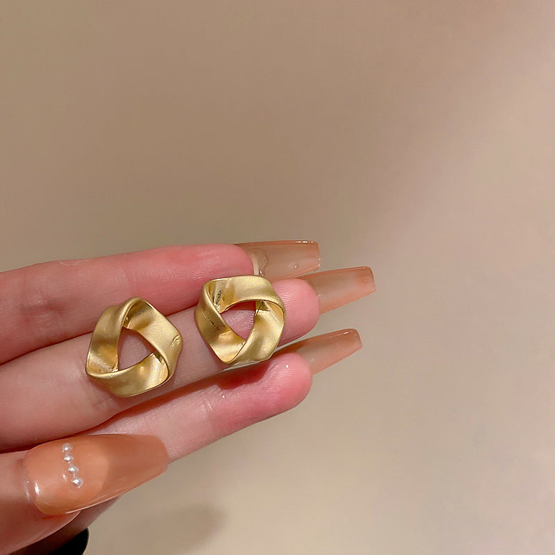 Twisted gold knot stud earrings with matte finish