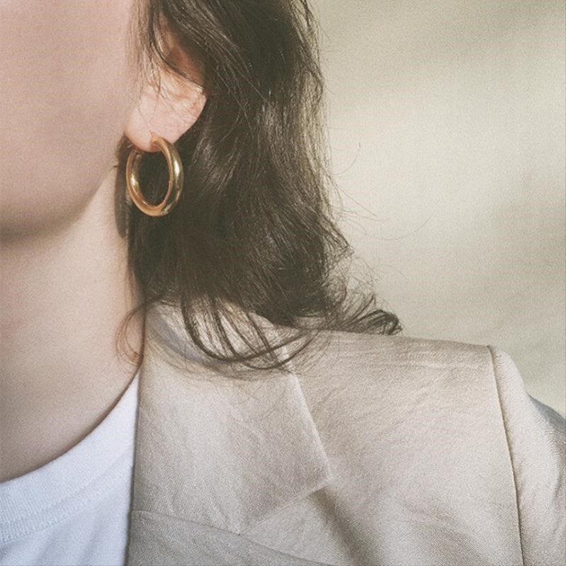 Classic gold hoop earring styled with minimal outfit