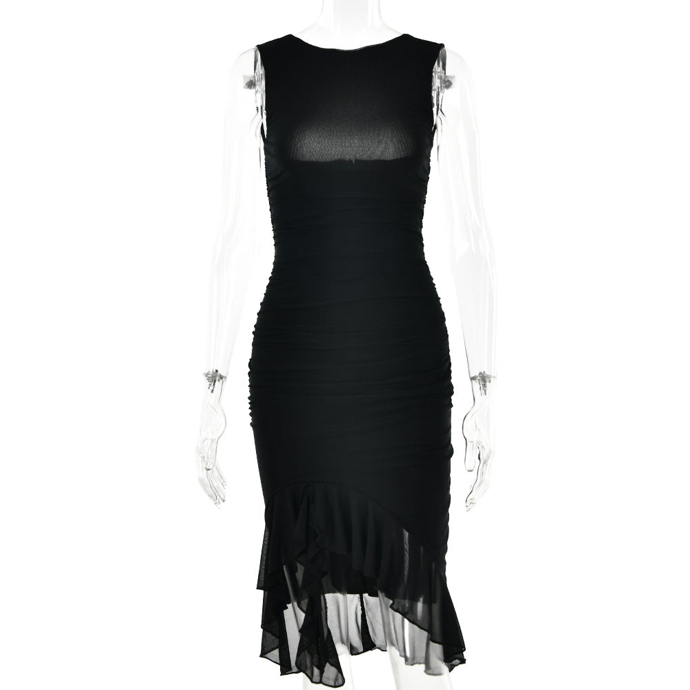 A model is wearing a black fitted sleeveless dress with ruched texture and asymmetrical ruffled hem against a white backdrop