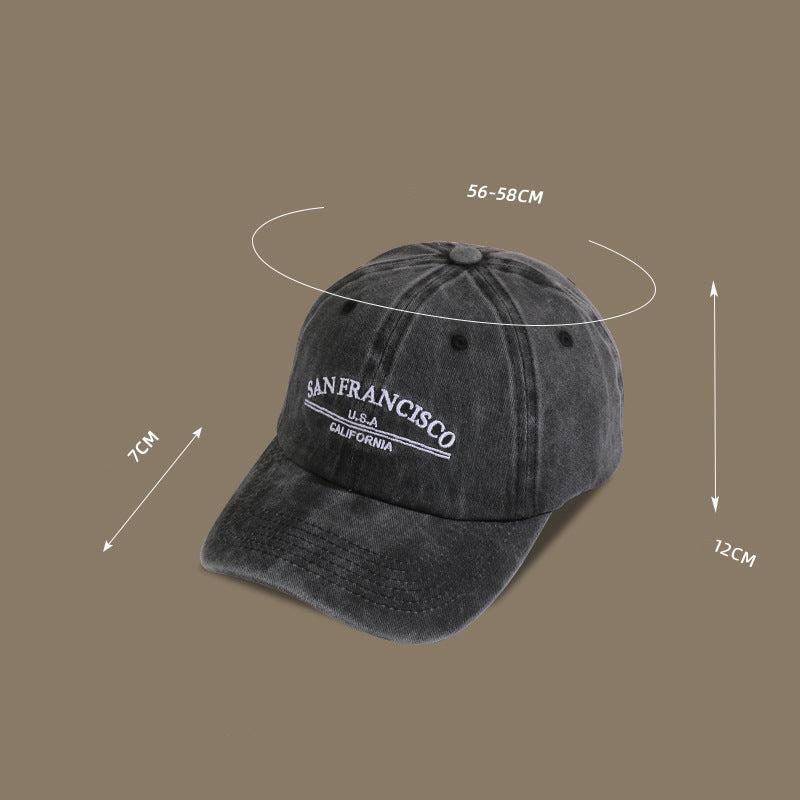 A charcoal washed cotton baseball cap with measurement details showing 56-58cm circumference and 7cm brim depth against taupe background