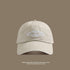 A beige washed cotton baseball cap with white 'San Francisco USA California' embroidery displayed against taupe background with UV protection text