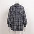 Navy blue plaid flannel shirt on mannequin, featuring oversized silhouette and button-front design