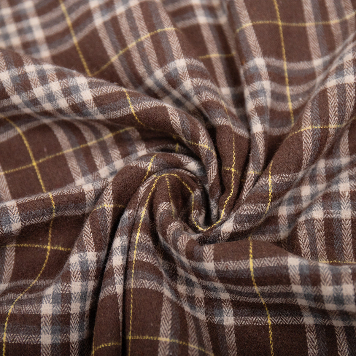Close-up of brown plaid flannel fabric texture showing herringbone weave and yellow accent lines