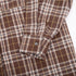 Close-up of shirt cuff detail showing button closure and plaid pattern alignment