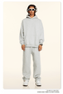 Model in light gray hoodie and sweatpants with white sunglasses and silver accessories