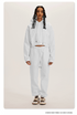White Sweatshirt and Joggers Set – Model in a white hoodie and joggers, styled with neutral sneakers