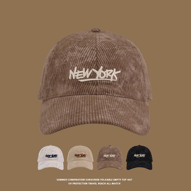 Brown corduroy baseball cap with white 'NEW YORK' graffiti-style embroidery, shown with color variants below