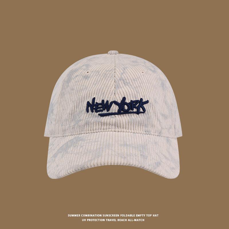 White corduroy baseball cap with navy 'NEW YORK' embroidery on front