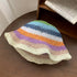 A pastel-toned crochet straw hat with rainbow stripes and a soft beige brim, perfect for casual sunny-day outfits.