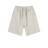Light gray cotton shorts with elastic waistband and drawstring ties, featuring relaxed fit and side pockets, displayed flat