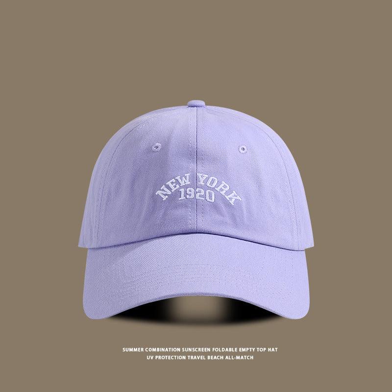 Light purple baseball cap with "New York 1920" embroidered in white on the front, displayed against a brown background