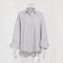 A white mannequin is wearing a gray striped oversized button-up shirt with rolled-up sleeves against a plain background