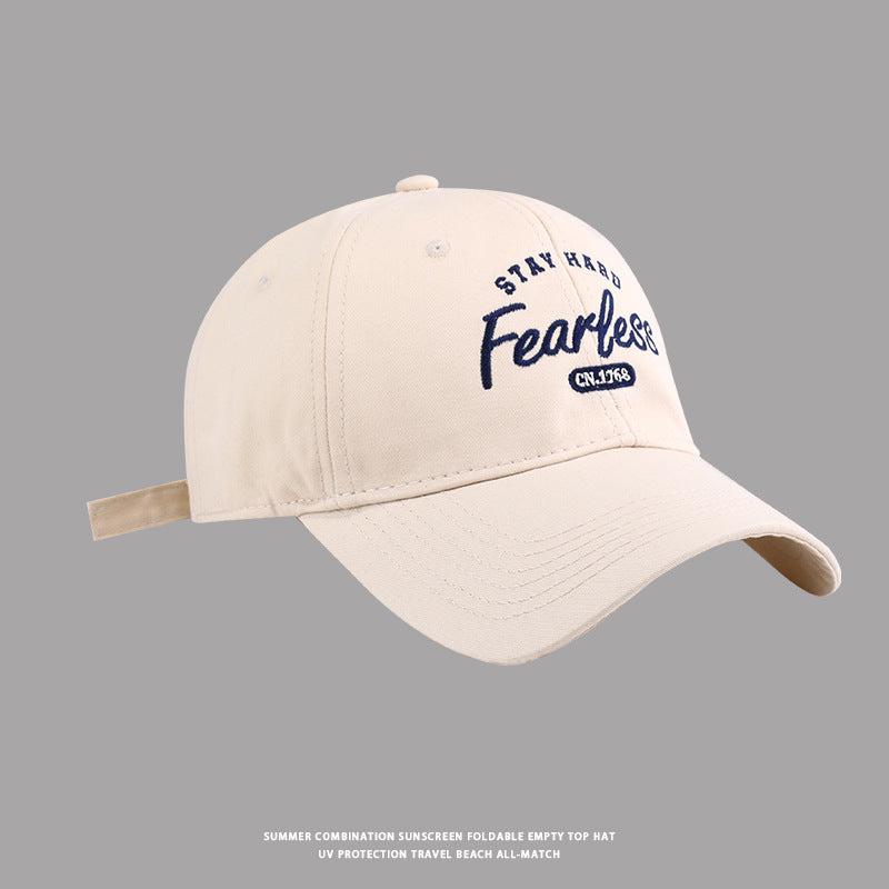 Beige baseball cap with navy Stay Hard Fearless embroidered design