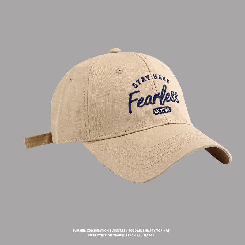 Khaki baseball cap with Stay Hard Fearless logo against gray background