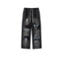 Black sweatpants with elastic waistband featuring white spray-painted graffiti designs including symbols and text