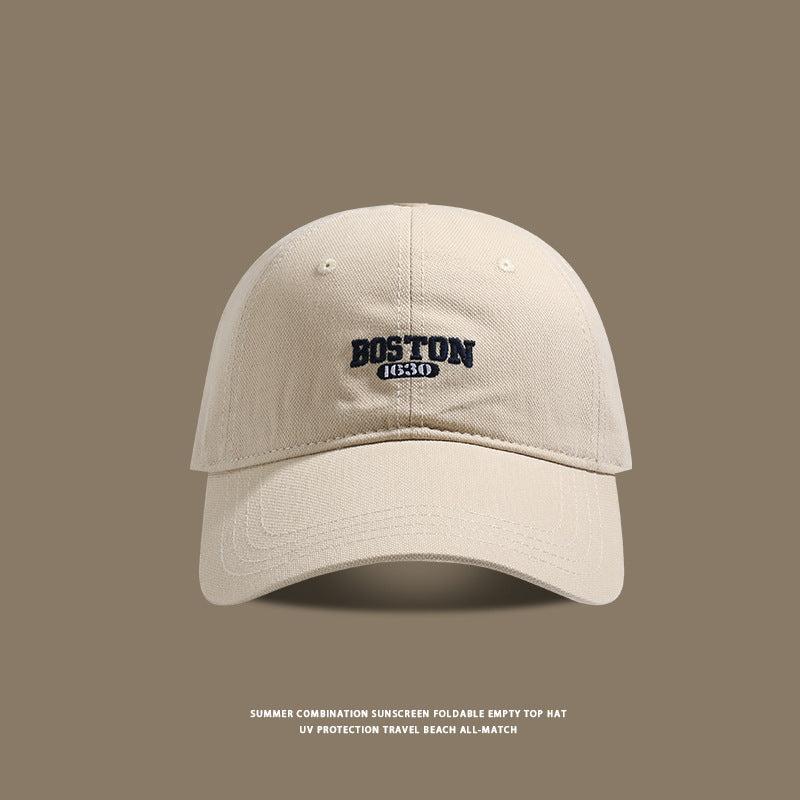 Beige colored baseball cap with Boston 1630 logo against neutral background