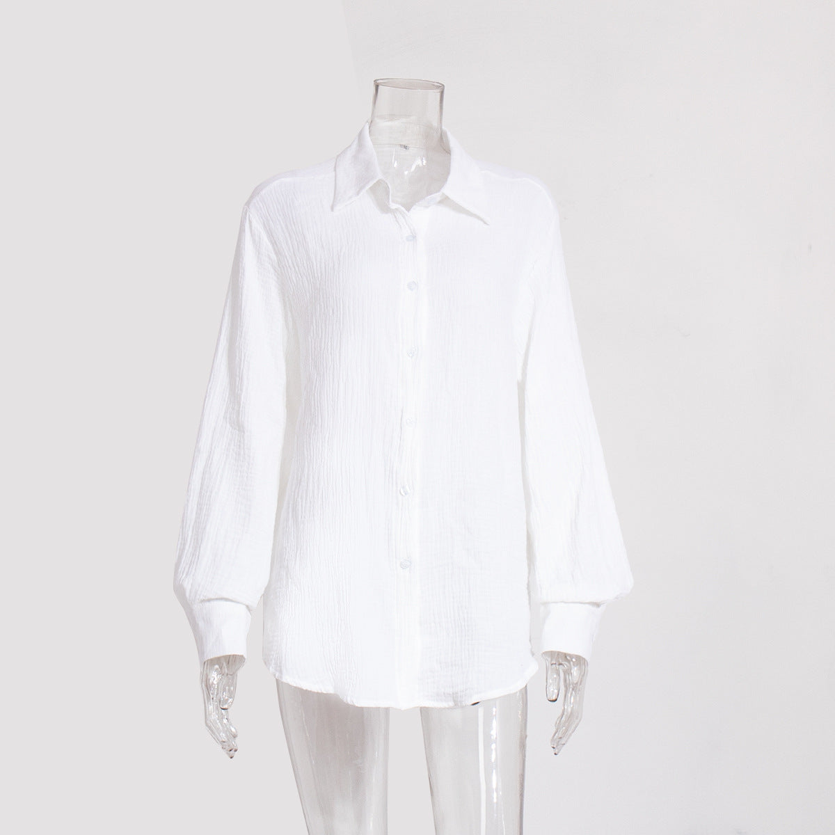 A white textured cotton button-down shirt with collar and long sleeves displayed on transparent mannequin against white background