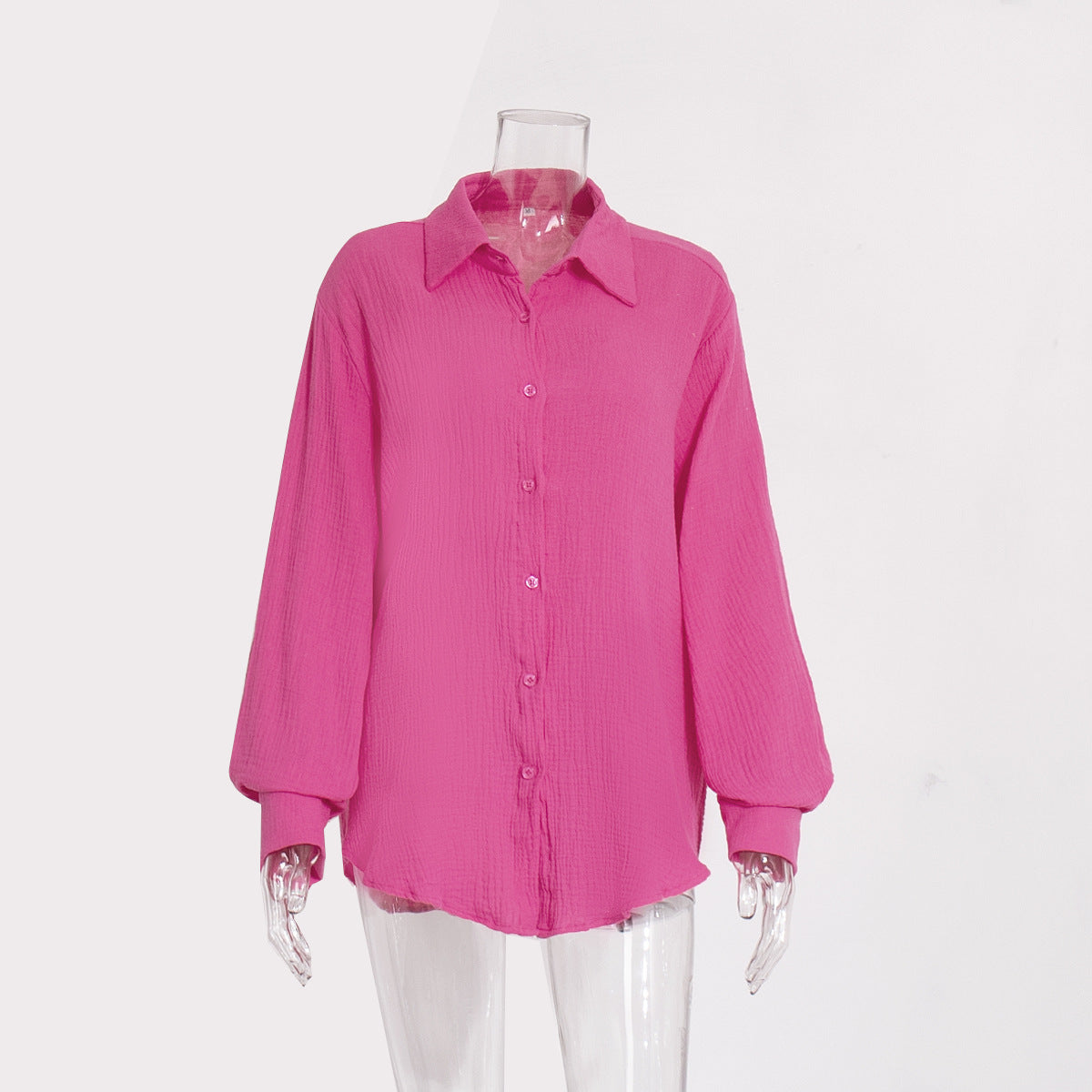 A hot pink textured cotton button-down shirt with collar and balloon sleeves displayed on transparent mannequin against white background