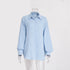 A light blue textured cotton button-down shirt with collar and balloon sleeves displayed on transparent mannequin against white background