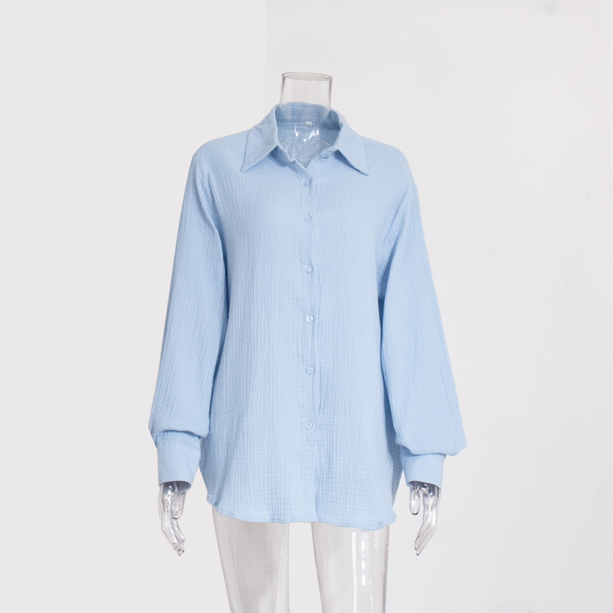 A light blue textured cotton button-down shirt with collar and balloon sleeves displayed on transparent mannequin against white background
