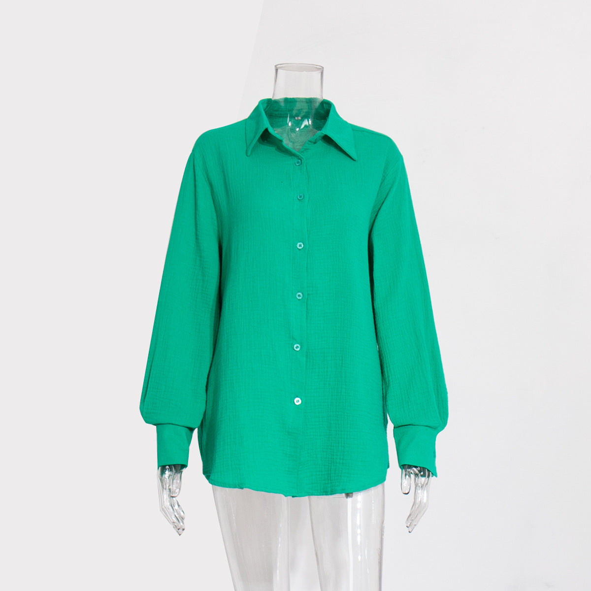 A bright green textured cotton button-down shirt with collar and balloon sleeves displayed on transparent mannequin against white background