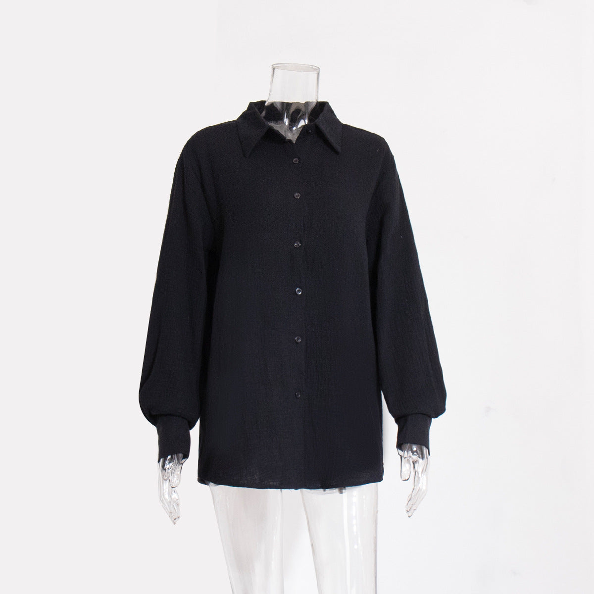 A black textured cotton button-down shirt with collar and balloon sleeves displayed on transparent mannequin against white background