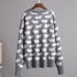 Gray knit sweater with repeating white sheep pattern, displayed on wooden hanger