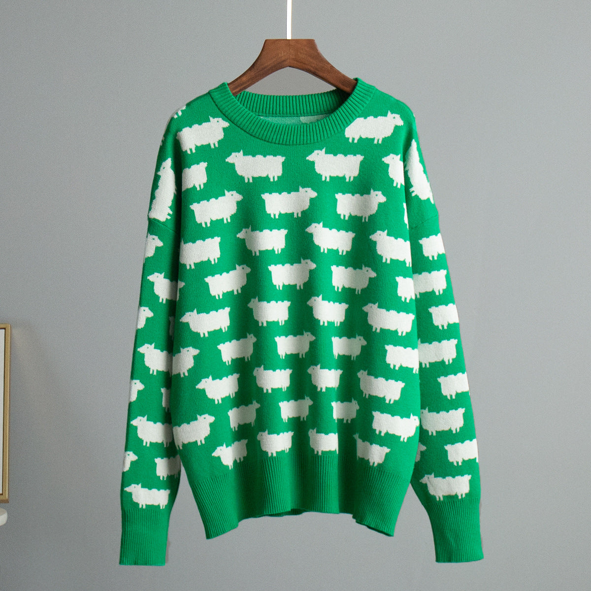 Bright green knit sweater featuring white sheep pattern throughout