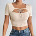 Close front view of beige ribbed crop top with cutout and tie detail.