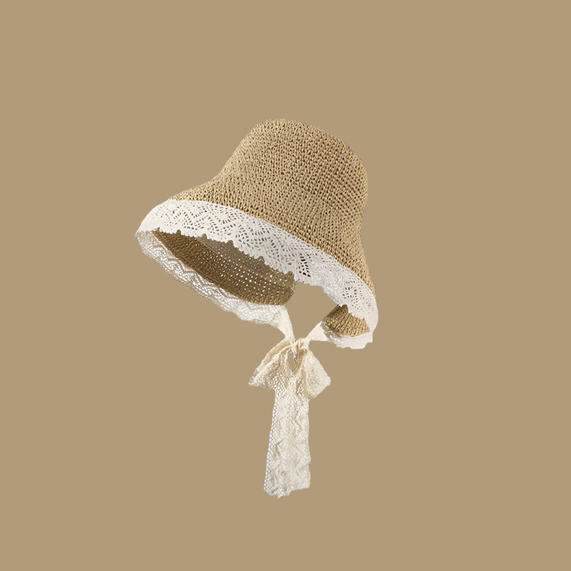 Khaki woven straw hat with a wide lace-trimmed brim and a tie under the chin, displayed on a solid brown background.